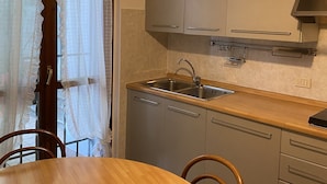 Uma cozinha compacta com pia, armários e uma mesa de jantar.