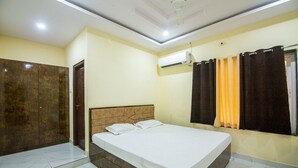 A bedroom with a bed, a wardrobe, and an air conditioning unit. - Bliss Farm Stay-IRIS (Hyderabad)