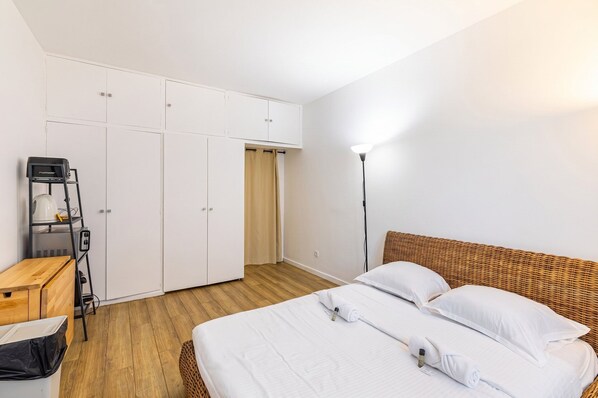 A bedroom with a bed, a wardrobe, a desk, and a lamp. - GuestReady - Comfortable studio in the 16th arr. (Paris)