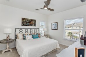 A bedroom with a bed, two bedside tables, a ceiling fan, and a window with blinds. - Beautiful house at Lost Key Resort Perdido Key (Perdido Key)