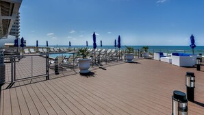 A wooden deck with lounge chairs and umbrellas, overlooking a pool and the sea. - Beautiful house at Lost Key Resort Perdido Key (Perdido Key)