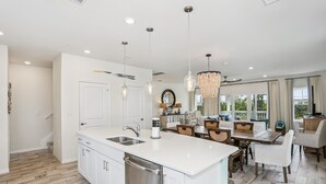 A modern kitchen with white cabinetry, a large island, and pendant lighting. - Beautiful house at Lost Key Resort Perdido Key (Perdido Key)