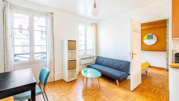Un espace de vie compact comprenant un canapé, une table à manger et une petite table ronde.