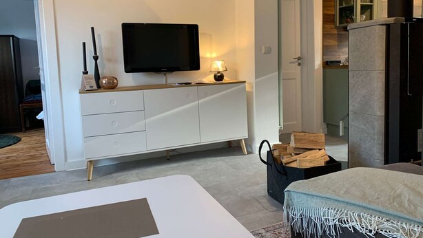 Un salon moderne doté d’un téléviseur à écran plat, d’un meuble blanc, d’une cheminée et d’un coin salon confortable.