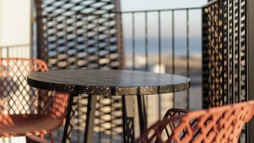 A round table with a metal frame and a single chair with a lattice design.