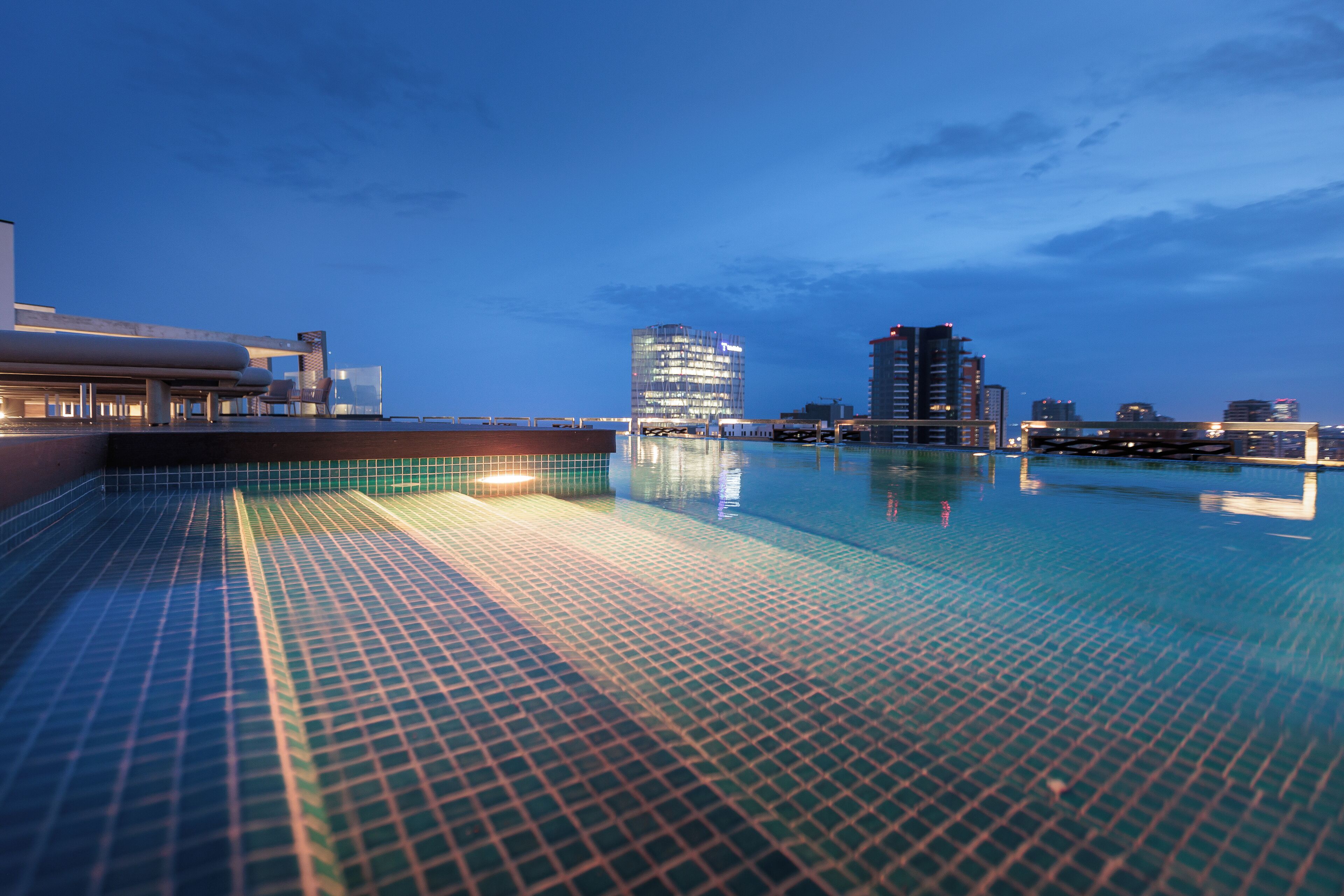 Een buitenzwembad, parasols bij het zwembad en ligstoelen