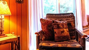 Un intérieur en bois avec un fauteuil en cuir, une lampe et une pancarte indiquant « BIENVENUE ».