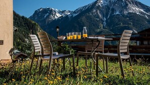 A table with chairs and a mountain view.