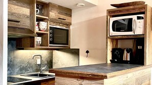 A kitchen with wooden cabinetry, a built-in microwave, a sink, and a dishwasher.