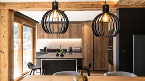 A modern kitchen with wooden accents, a central island, and pendant lighting.