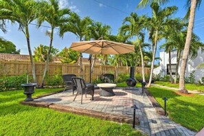 A patio area with outdoor furniture, a round table, and a large umbrella.