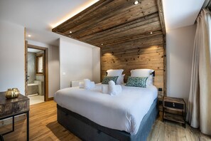 Relax in a cozy retreat with a large bed, bedside tables, and a wooden floor.