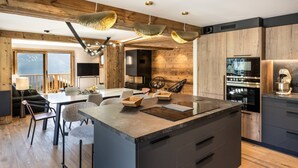 A modern kitchen with a central island, wooden accents, and contemporary lighting fixtures.