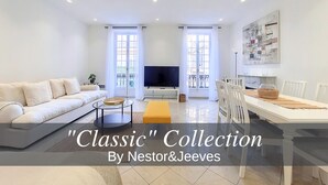 A modern living room with a sofa, TV, dining table, and chairs. - N&J - JACARANDA- Central, very close sea (Niza)