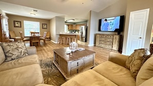 A living room with a sofa, coffee table, and a television. - House on Canal access to Lake! (Okeechobee)