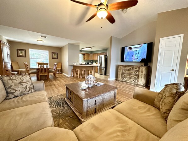 A living room with a sofa, coffee table, and a television. - Water view Home with Dock on Canal with access to Lake! (Okeechobee)
