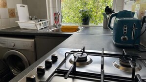 Eine Küche mit Gasherd, Waschmaschine und Toaster.