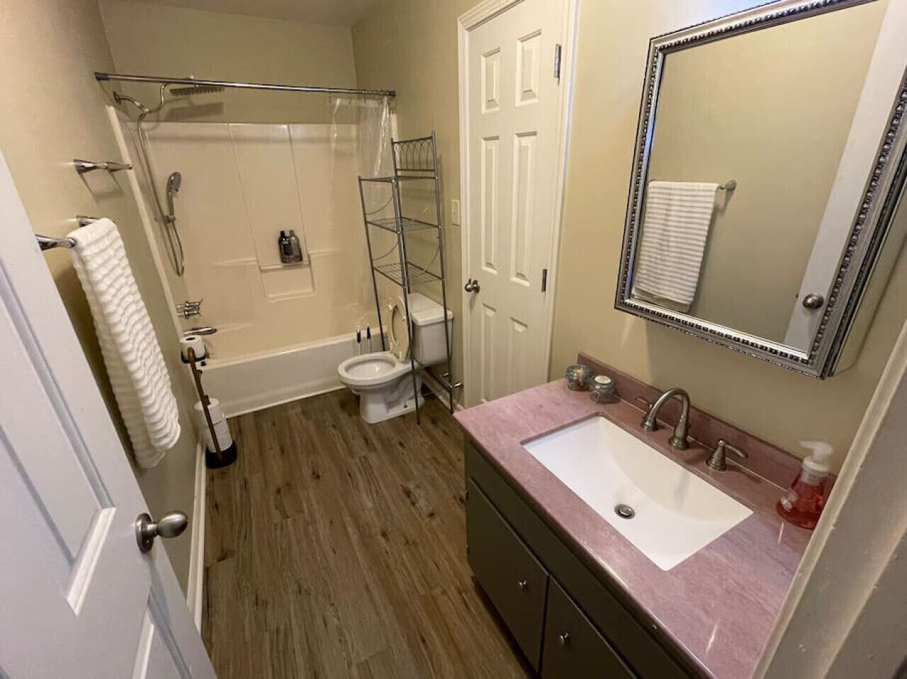 Un baño con ducha, inodoro, lavabo y espejo.