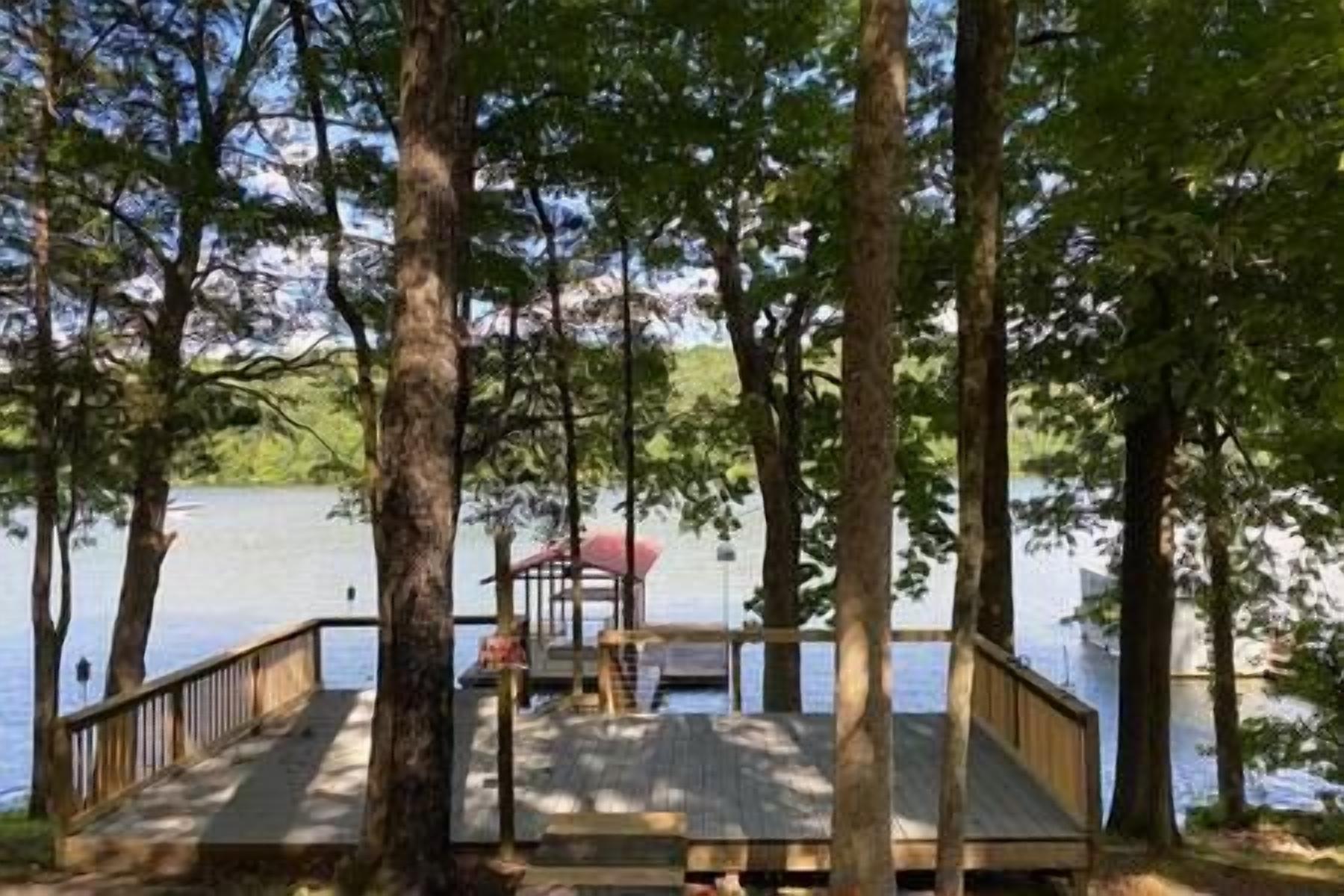 Une jetée en bois s’avançant dans un lac, entourée d’arbres.
