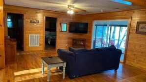 Un intérieur en bois avec un canapé, un téléviseur et un ventilateur de plafond.