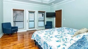 Ein Schlafzimmer mit Bett, Stuhl und Deckenventilator.