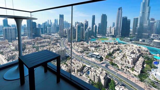 A high-rise room with a panoramic city view, a modern table, and a glass railing. - Luxury Burj Royale Burj Khalifa & Fountain view (Dubai)
