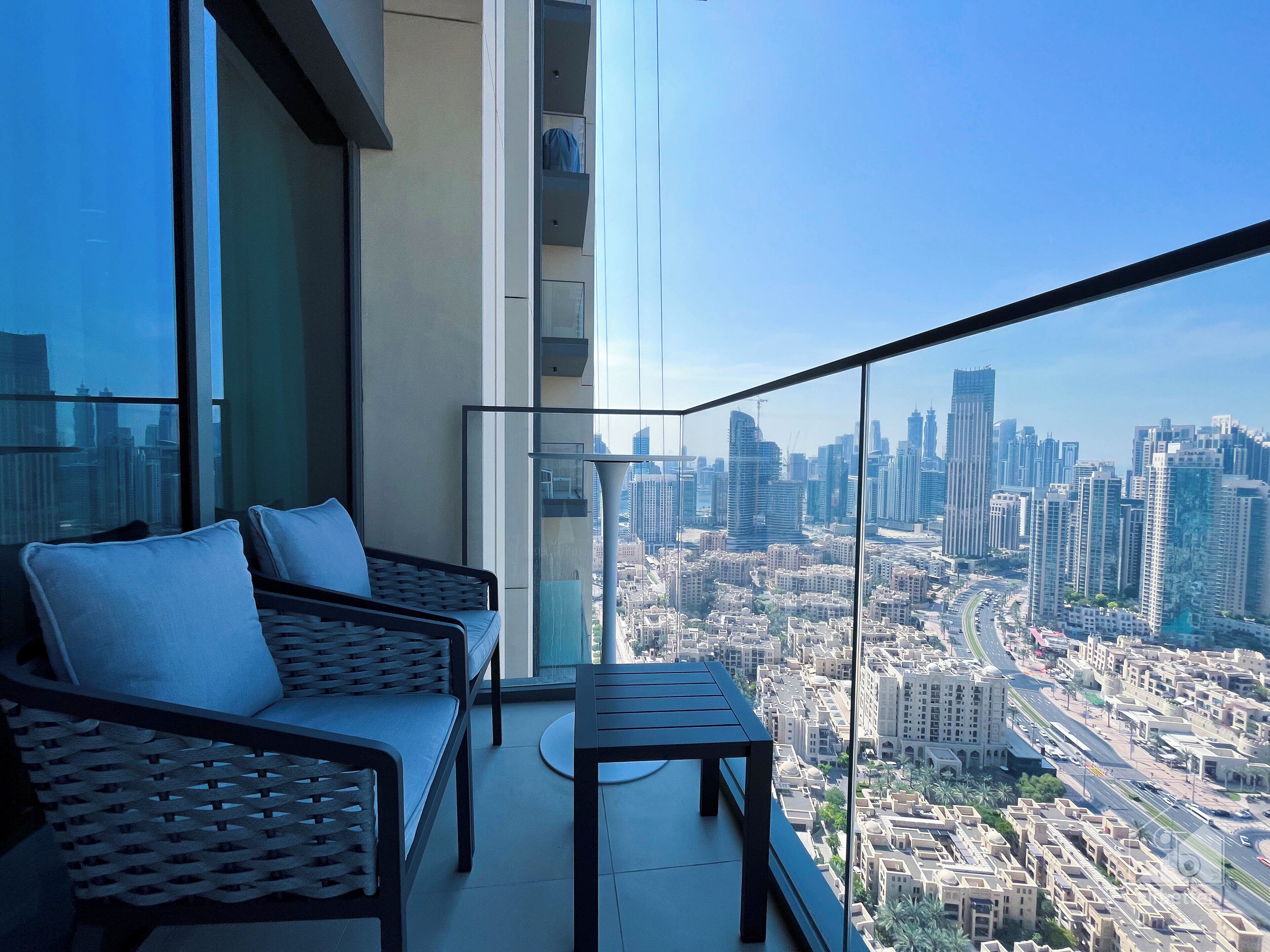 A balcony with a city view, a sofa, and a table.