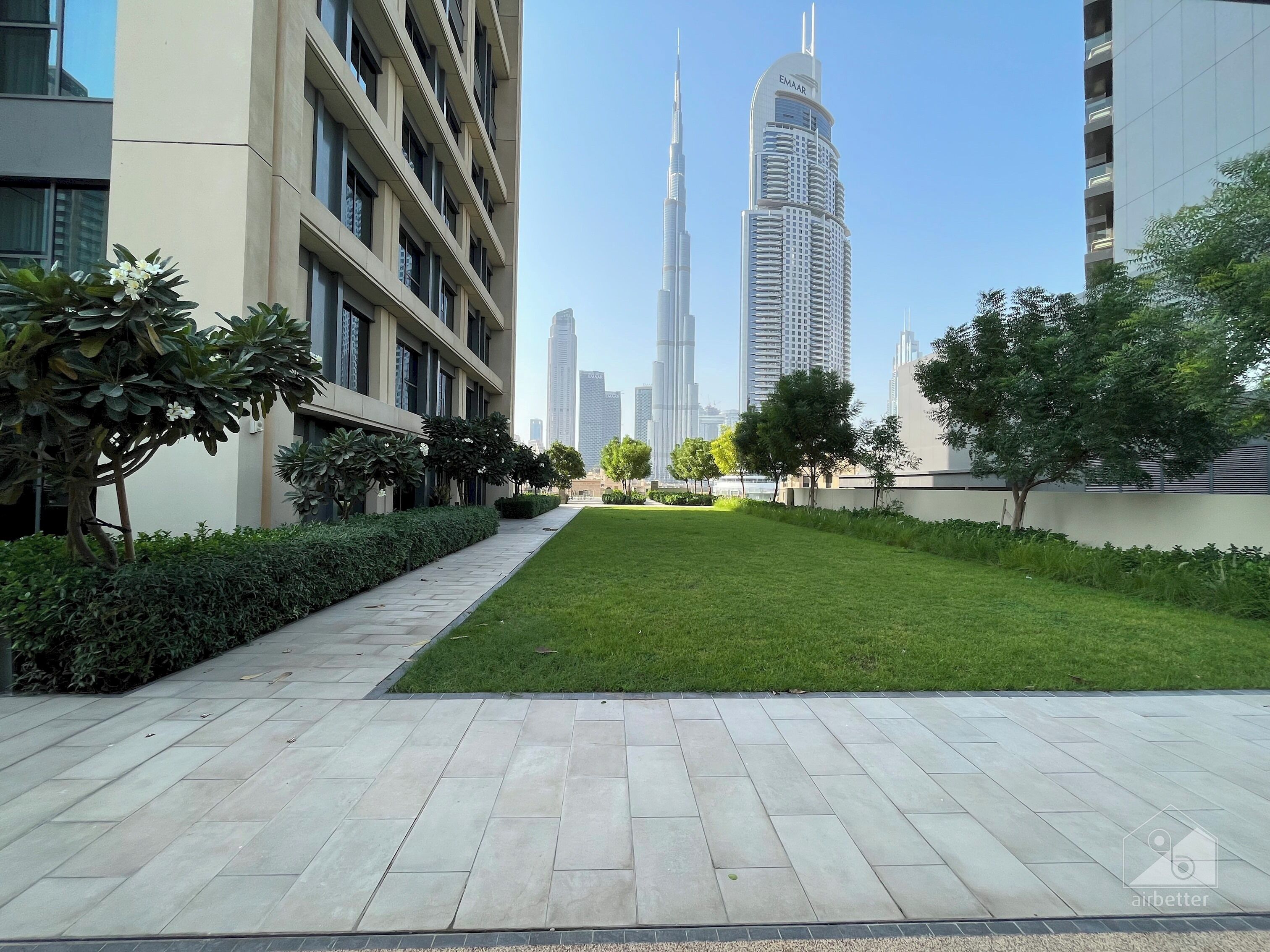 A modern building with a paved walkway and a grassy area.
