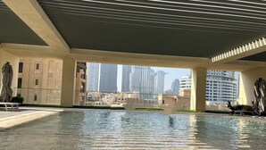 A rooftop pool with a view of high-rise buildings. - Luxury Burj Royale Burj Khalifa & Fountain view (Dubai)