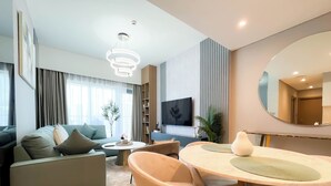 A modern living room with a sofa, chairs, a dining table, and a TV. - Luxury Burj Royale Burj Khalifa & Fountain view (Dubai)