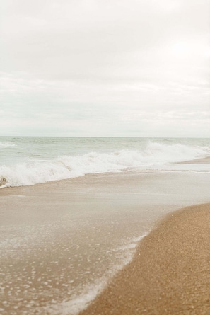 A beach with waves approaching the shore.