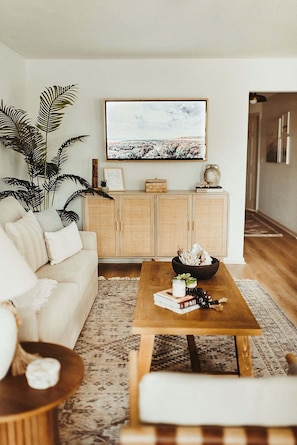 A living room with a sofa, a coffee table, a TV, and a cabinet.