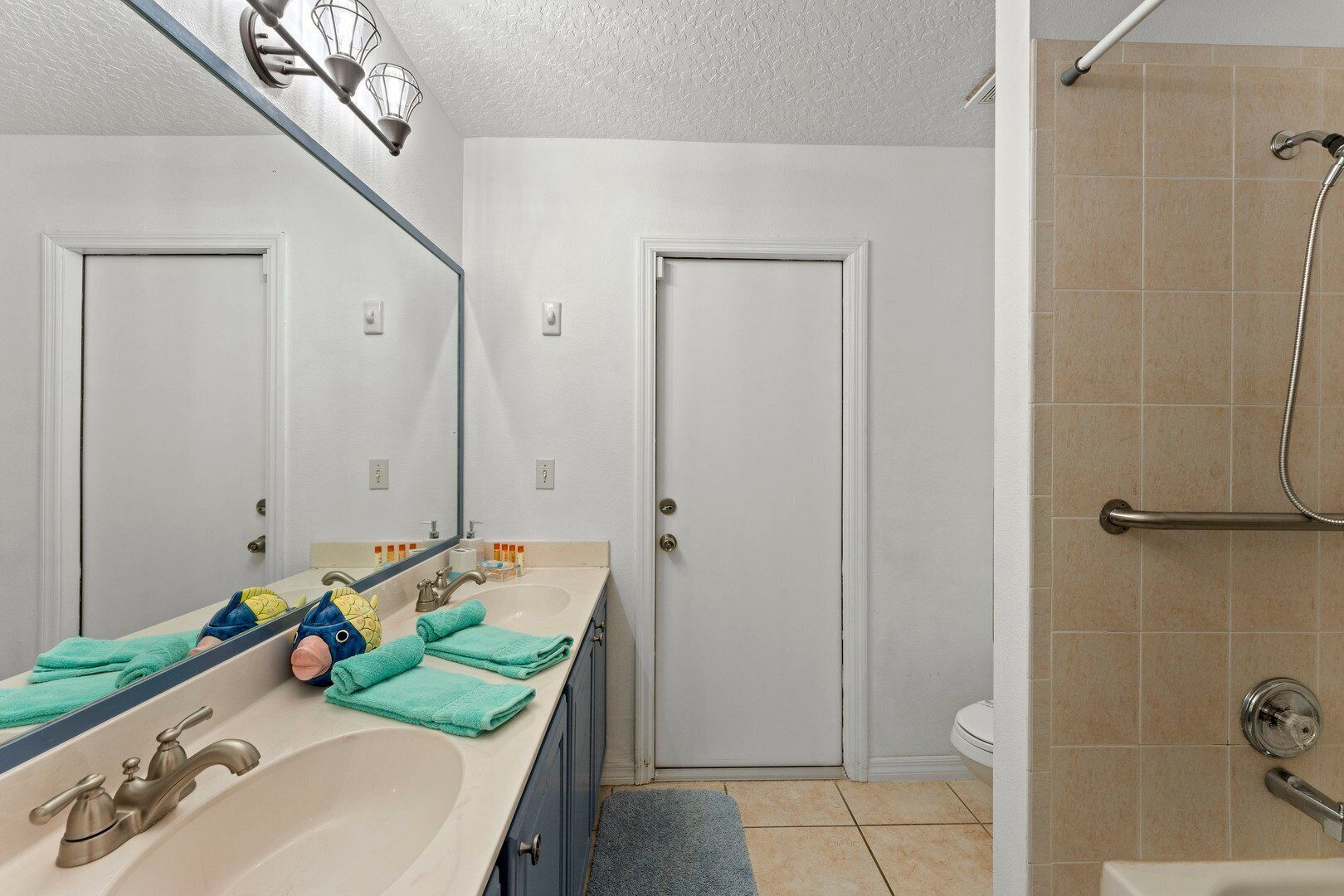 A bathroom with a sink, mirror, and two doors.