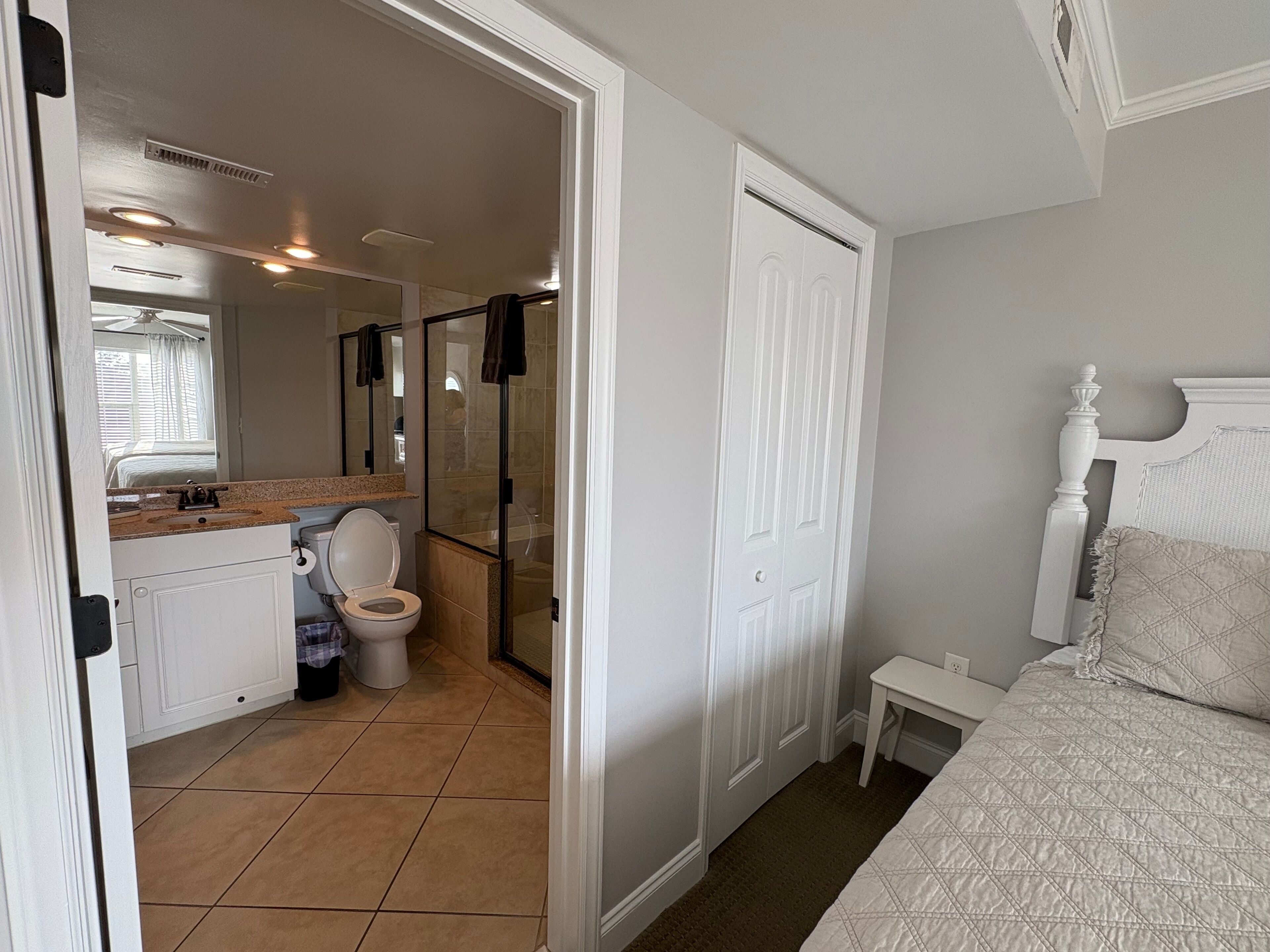 Une salle de bain comprenant des toilettes, un lavabo et un espace douche.