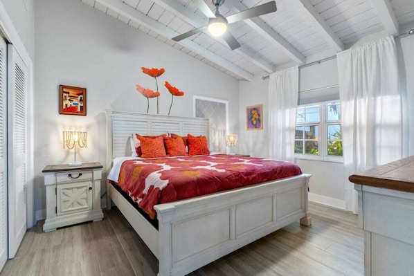 A bedroom with a white bed, red and white bedding, a ceiling fan, and a window with curtains. - Delray Beach's Ultimate Retreat Asian-Inspired Oasis and Exclusive Private Patio (Delray Beach)