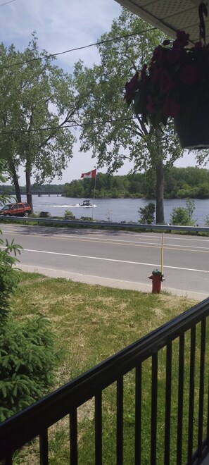 Vista di un lago con una bandiera canadese, un idrante rosso e una strada con un guardrail.