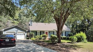 A single-story house with a garage, a driveway, and a tree in front. - Quiet retreat (Macon)