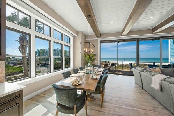 A spacious dining area with a view of the beach, large windows, and a modern interior design. - Beachfront Luxury - Resort Pool - Steps to Village (Siesta Key)