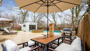 A backyard with a wooden deck, outdoor seating, a barbecue grill, and a swimming pool. - 10 Min to Downtown~Luxury Home w/ Pool, Outdoor TV (Austin)