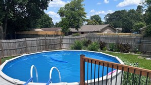 A rectangular swimming pool with a wooden deck and metal railings. - Visiting family need space? Enjoy our spacious & serene abode. Plenty of space! (Warner Robins)