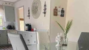 A dining area with a glass table, metal chairs, and a decorative plant. - Visiting family need space? Enjoy our spacious & serene abode. Plenty of space! (Warner Robins)
