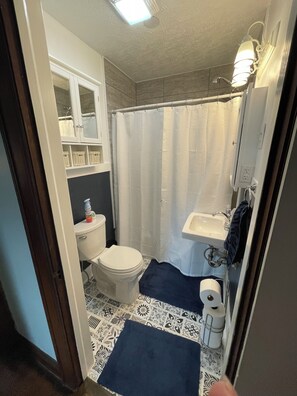 Ein kleines Badezimmer mit Toilette, Waschbecken und Duschvorhang.