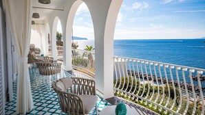 A balcony with wicker furniture, a patterned floor, and a view of the sea. - Villa Biancalisa - Sea View Infinity Pool - Newly refurbished - Beachfront (Massa Lubrense)
