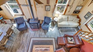 A cozy living room with a fireplace, a sofa, a coffee table, and a bookshelf. - Stratton; 6 min. King beds. Pool Table. Wood Stove. Dog friendly (Jamaica)