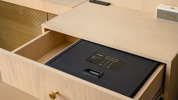 Une cuisine compacte dotée d’un four à micro-ondes encastré, d’un tiroir pour appareils électroménagers de couleur rouge et d’un plan de travail en bois.