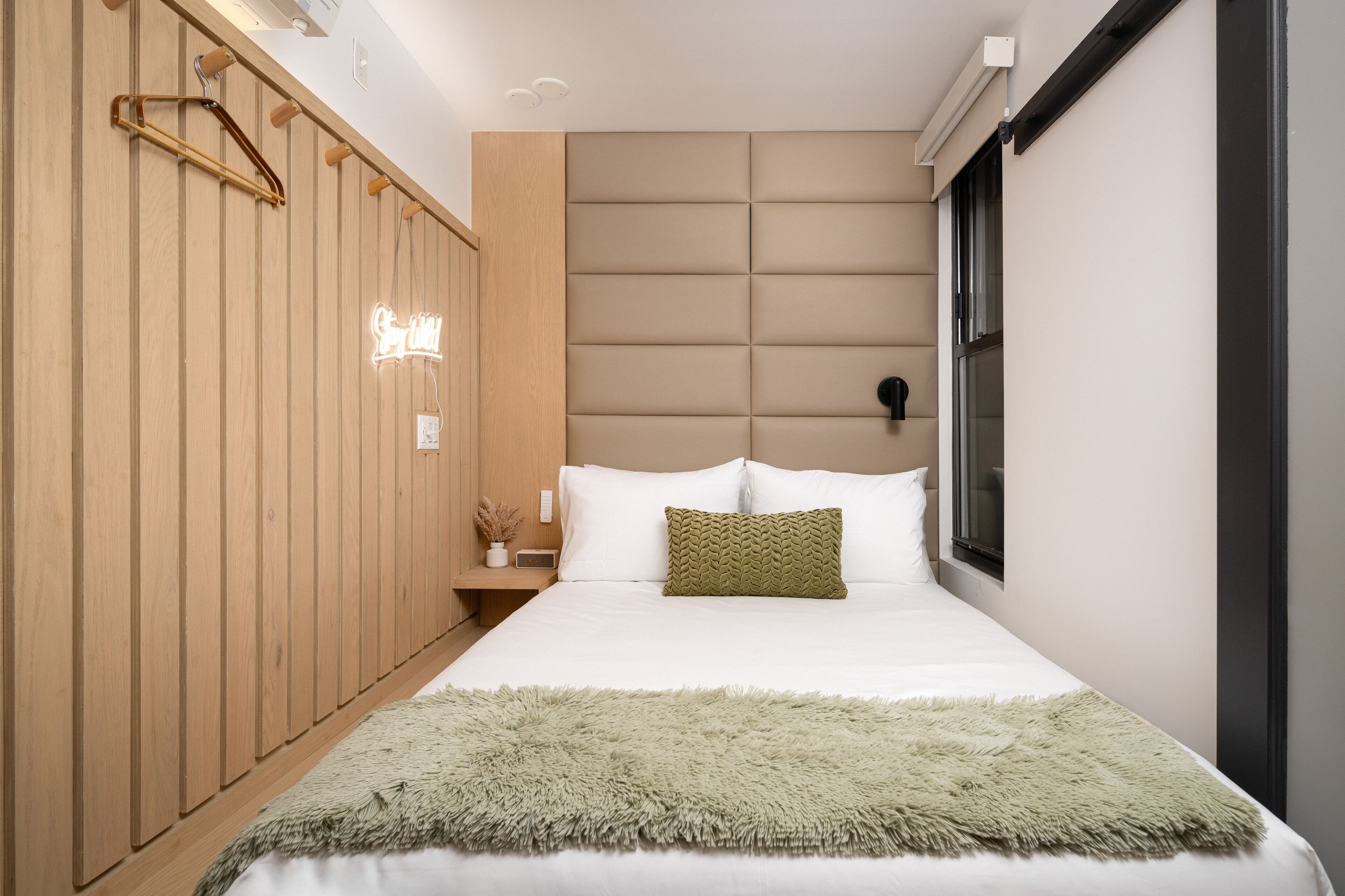 Ein modernes Schlafzimmer mit einem großen Bett, einem Holzschrank und einem kleinen Nachttisch.
