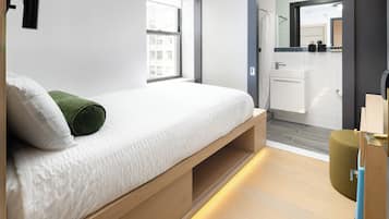Ein modernes Schlafzimmer mit Bett, begehbarem Kleiderschrank und Bad.
