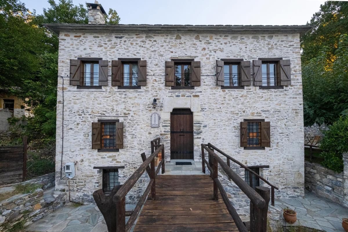 A stone building with a wooden staircase leading to a door.