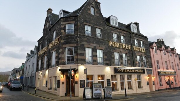 A historic building with the name 'Portree Hotel' and 'Antlers Bar & Grill' on the ground floor. - The Portree Hotel  (Portree)