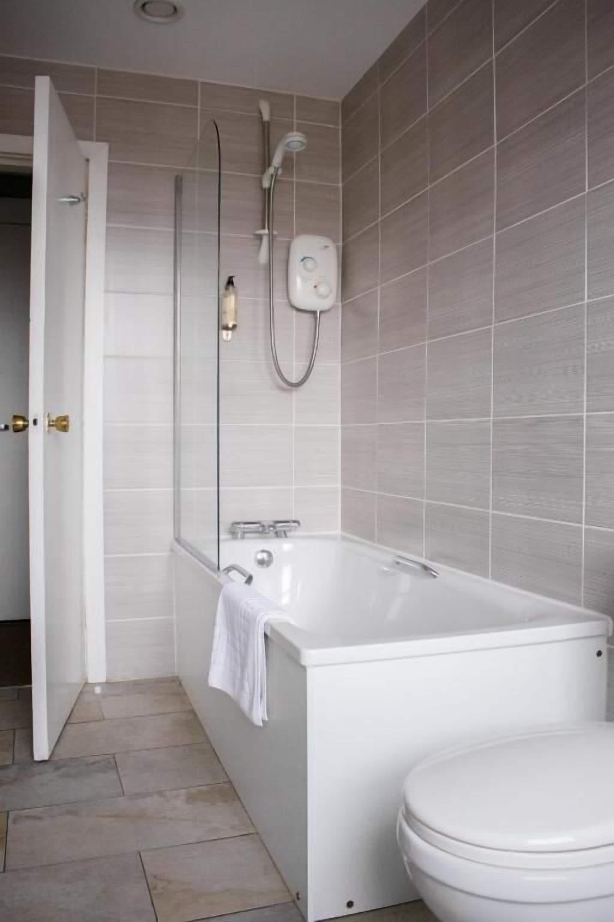 Ein modernes Badezimmer mit Badewanne, Toilette und Dusche.